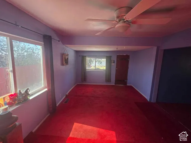 Recessed ceiling with ceiling fan, multiple windows, and a built-in storage area