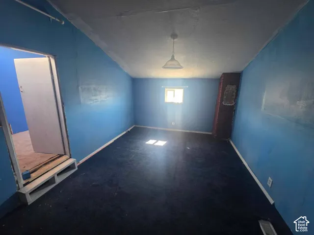 Room with blue walls, a single window, a brick chimney, and a ceiling-mounted light fixture