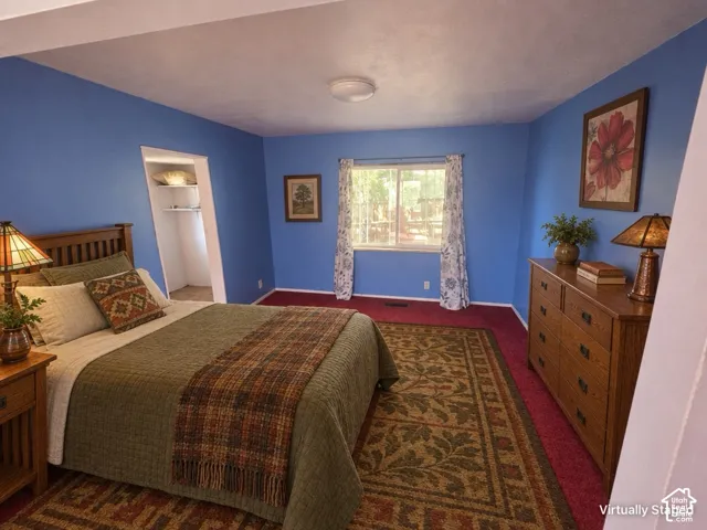 Recessed closet with shelving, overhead flush-mount lighting, and a single window with curtain rods