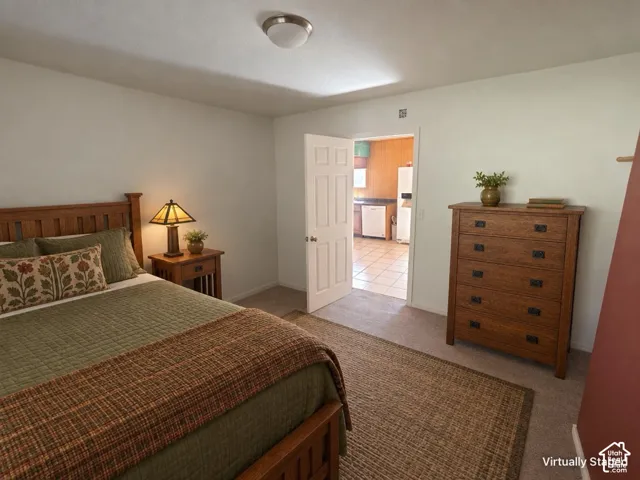 Carpeted flooring, recessed ceiling lighting, and a paneled interior door