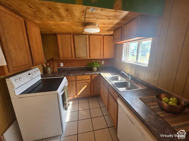 U-shaped kitchen layout featuring wood cabinetry, textured countertops, and tile flooring