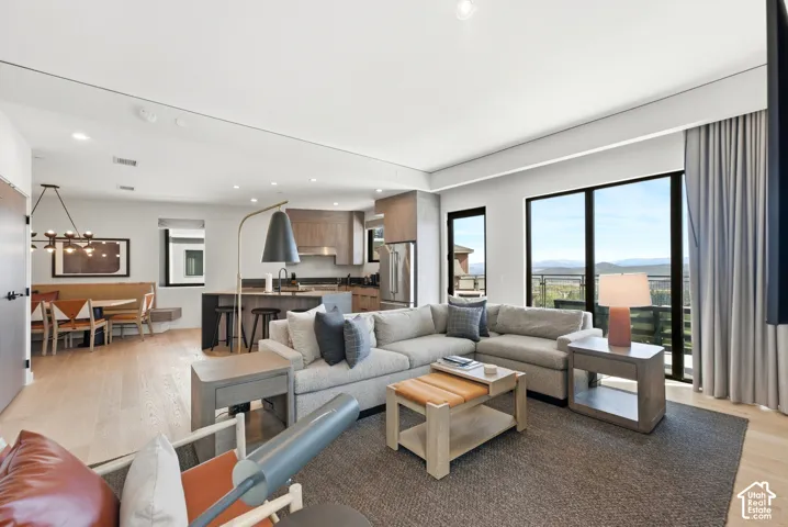Open-concept living space featuring wood-finish flooring, recessed lighting, and large windows