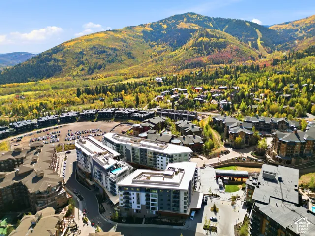 Aerial perspective showcasing multi-level residential structures, a mountain backdrop, and surrounding natural foliage