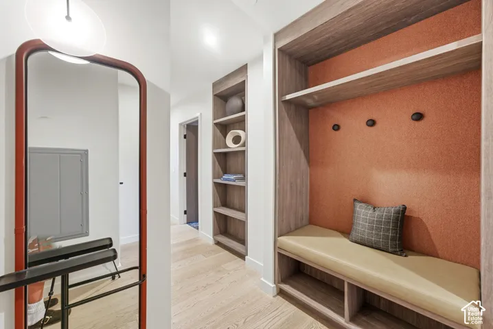 Built-in entry bench with upholstered seating, integrated shelving, and wall hooks