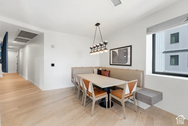 Light wood-finish flooring throughout, with a built-in dining bench and integrated wall shelving