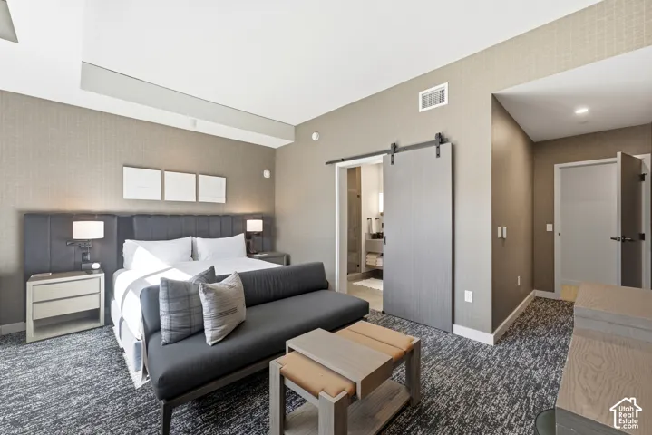 Integrated ceiling lighting, textured wall coverings, wood-finish barn door, recessed lighting, and wall-mounted bedside lighting