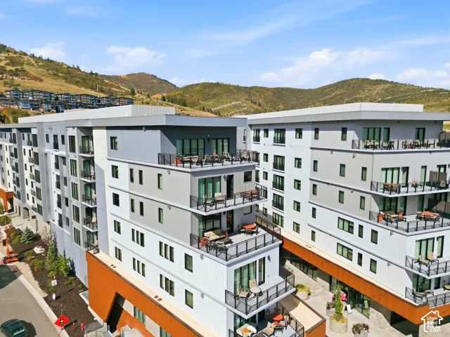 Contemporary multi-story architecture with balconies, expansive windows, and a flat roofline