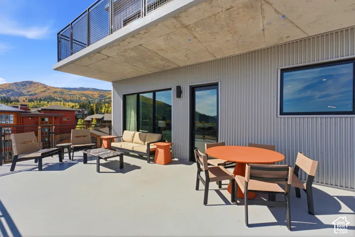 Expansive outdoor terrace with a concrete floor, corrugated metal siding, and black-framed windows