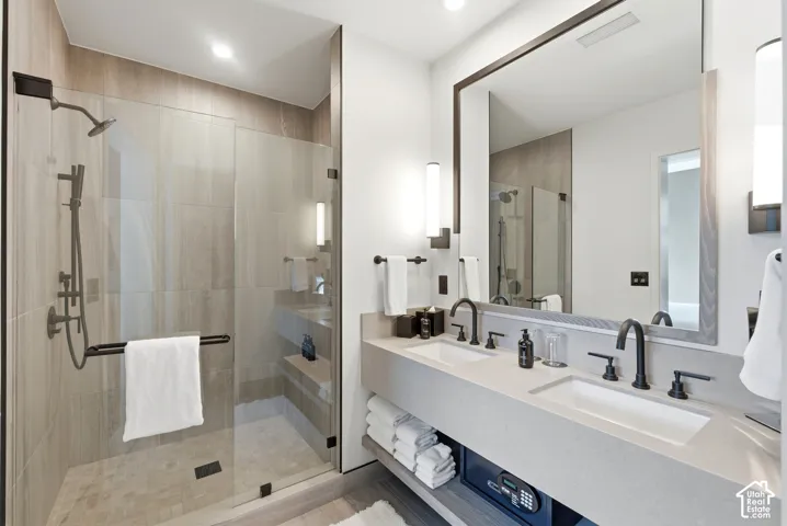 Glass-enclosed shower with a handheld sprayer and integrated bench