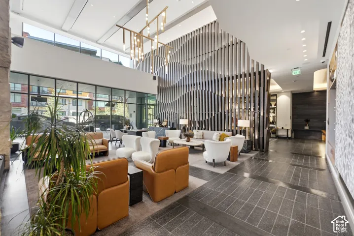 Expansive lobby featuring a high ceiling, full-height windows, a decorative slat wall, and recessed lighting