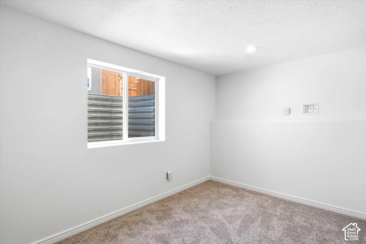 Bedroom #5 - Recessed lighting, light-toned carpeting, white painted walls, a white-framed window and closet