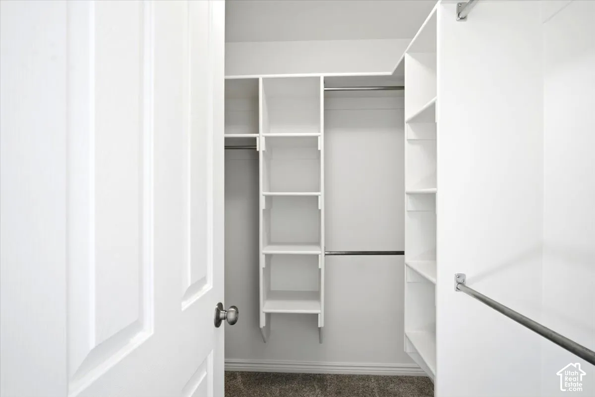 Master Bedroom custom closet organization system featuring white shelving and chrome hanging rods
