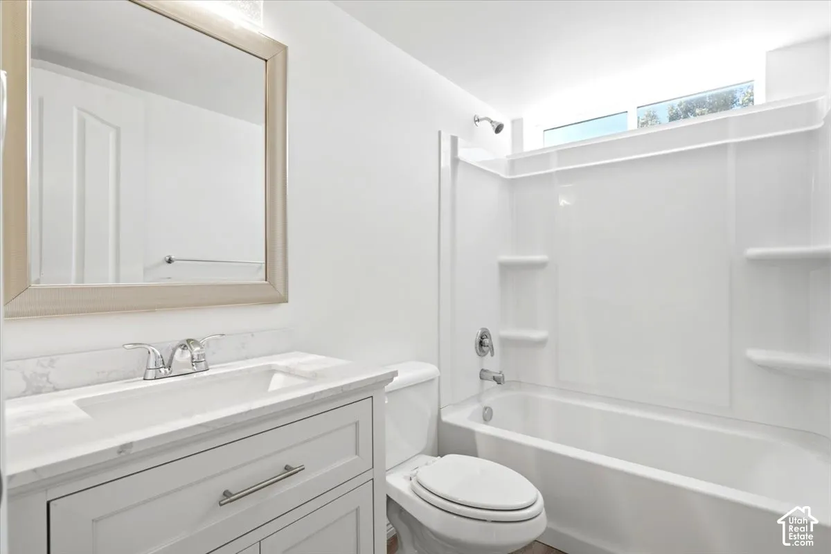 Bathroom #3 - White vanity with a light-toned countertop, framed mirror, and chrome fixtures