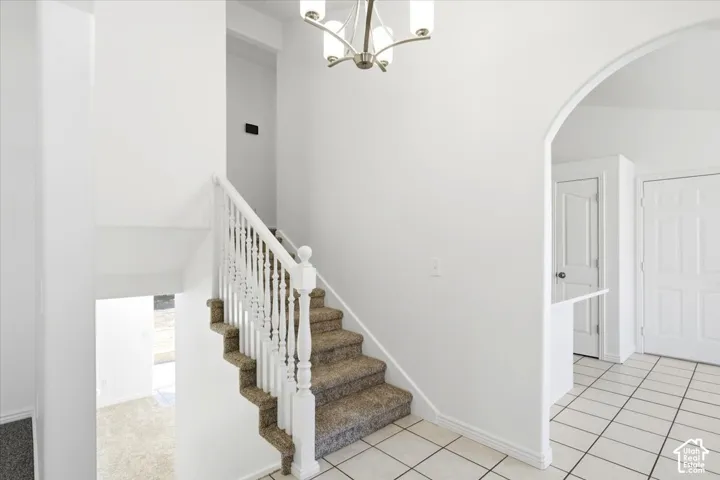 Carpeted staircase with white balusters, leading to an upper level