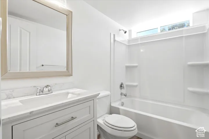 Bathroom #3 - White vanity with a light-toned countertop, framed mirror, and chrome fixtures