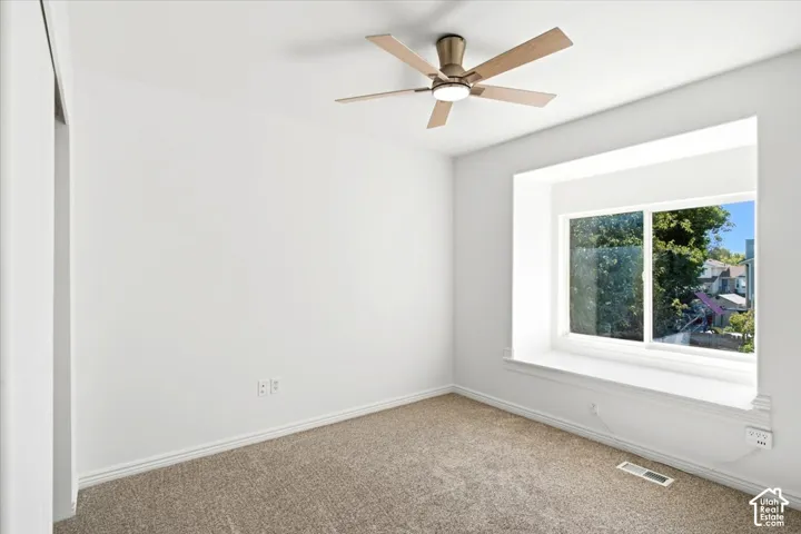 Bedroom #2 - Recessed window with deep window seat and storage, overhead ceiling fan with lighting, and neutral carpeting