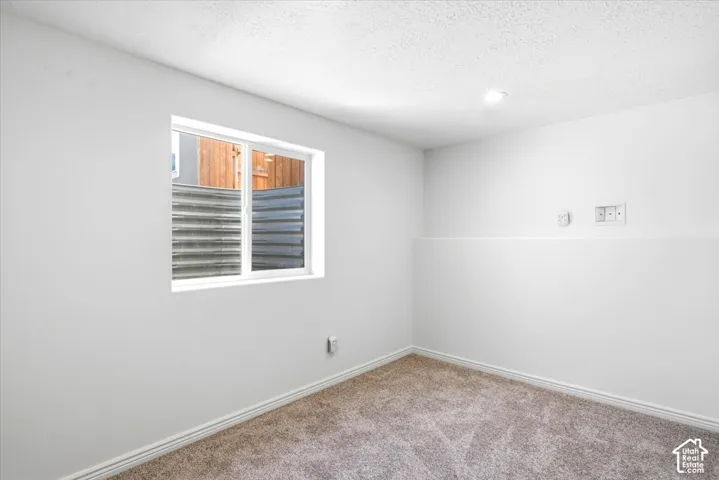 Bedroom #5 - Recessed lighting, light-toned carpeting, white painted walls, a white-framed window and closet
