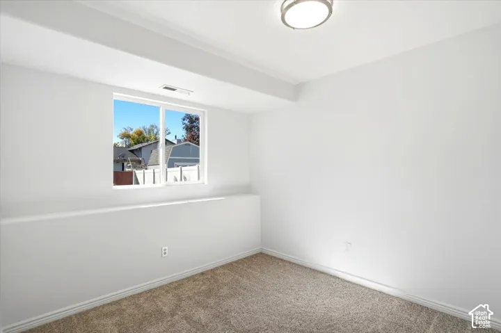 Bedroom #4 - Neutral wall finishes with a single window and recessed lighting