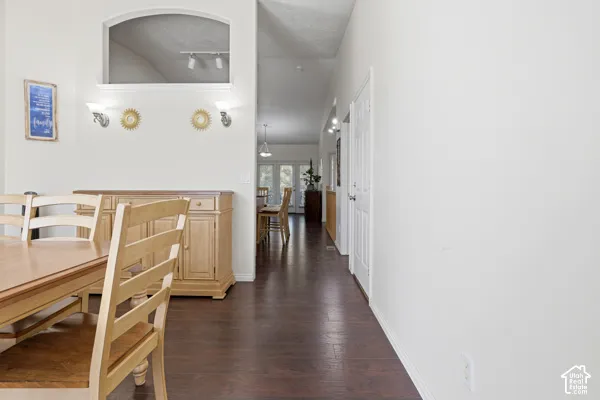 Dark wood-finish flooring, architectural arched wall niche, and dual wall-mounted light fixtures
