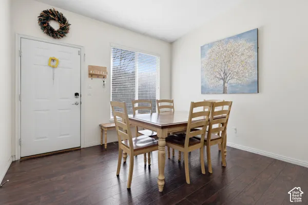 Interior space featuring wood-finish flooring, a white paneled door, and a horizontal window with slatted blinds