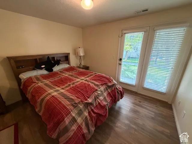 Wood-finish flooring with dual glass-paneled doors, integrated blinds, and a neutral wall color