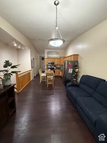 Vaulted ceilings, wood-finish flooring, recessed lighting, and kitchen with wood cabinetry