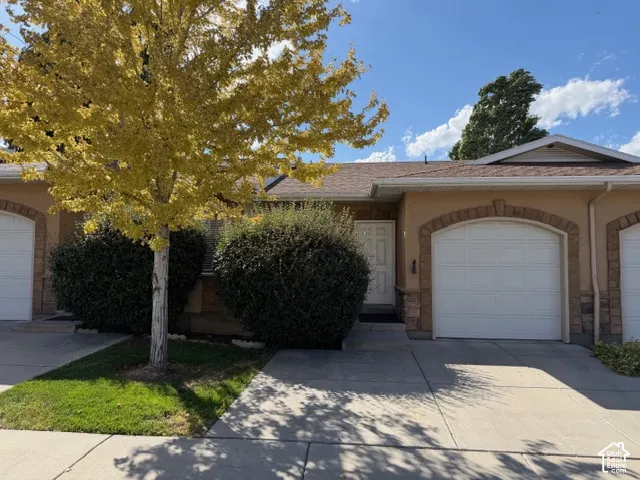 Stucco exterior with stone accents and arched garage door