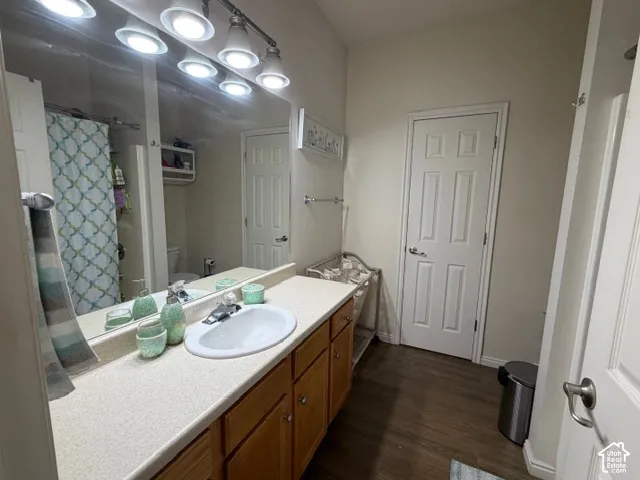 Spacious master bathroom featuring a double vanity with wood cabinetry, quartz countertop, and white ceramic sink