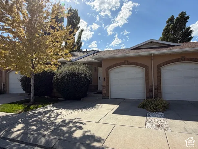 Stucco exterior with stone accents and dual garage doors