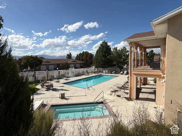 Outdoor swimming pool with integrated spa and surrounding concrete decking
