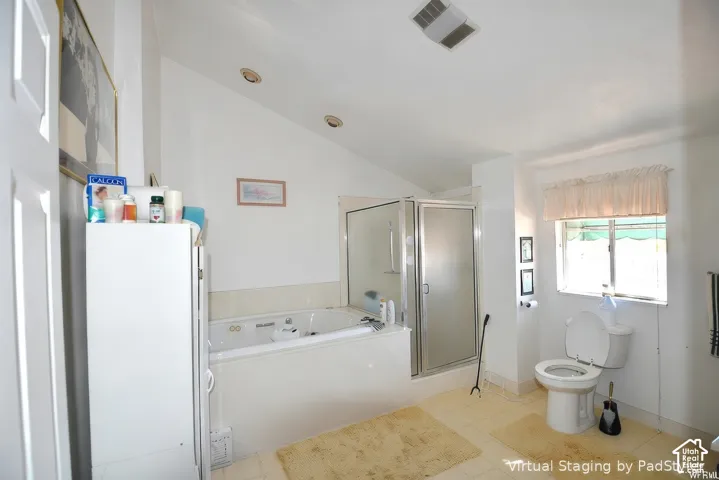 Soaking tub, enclosed shower with glass door, window with natural light, recessed lighting, and vaulted ceiling