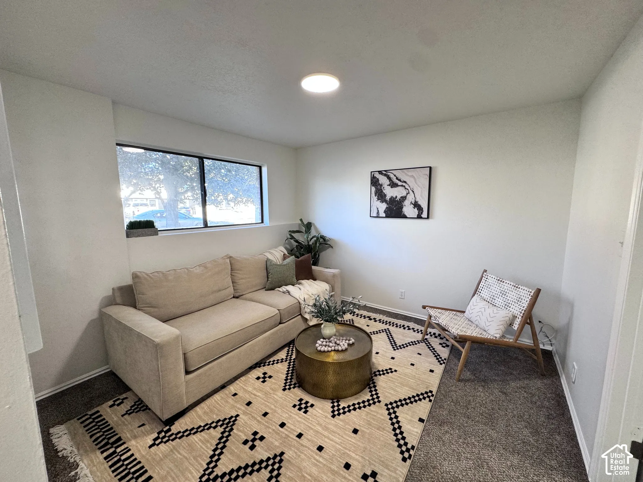 Recessed lighting, white walls, and a large window provide illumination