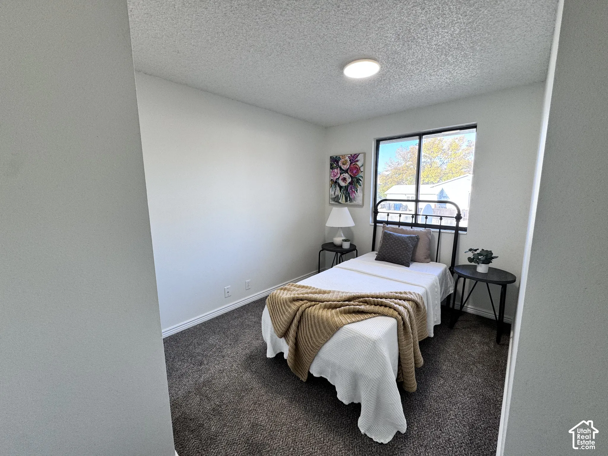 Wall-to-wall carpeting, recessed ceiling lighting, and a window with a dark frame