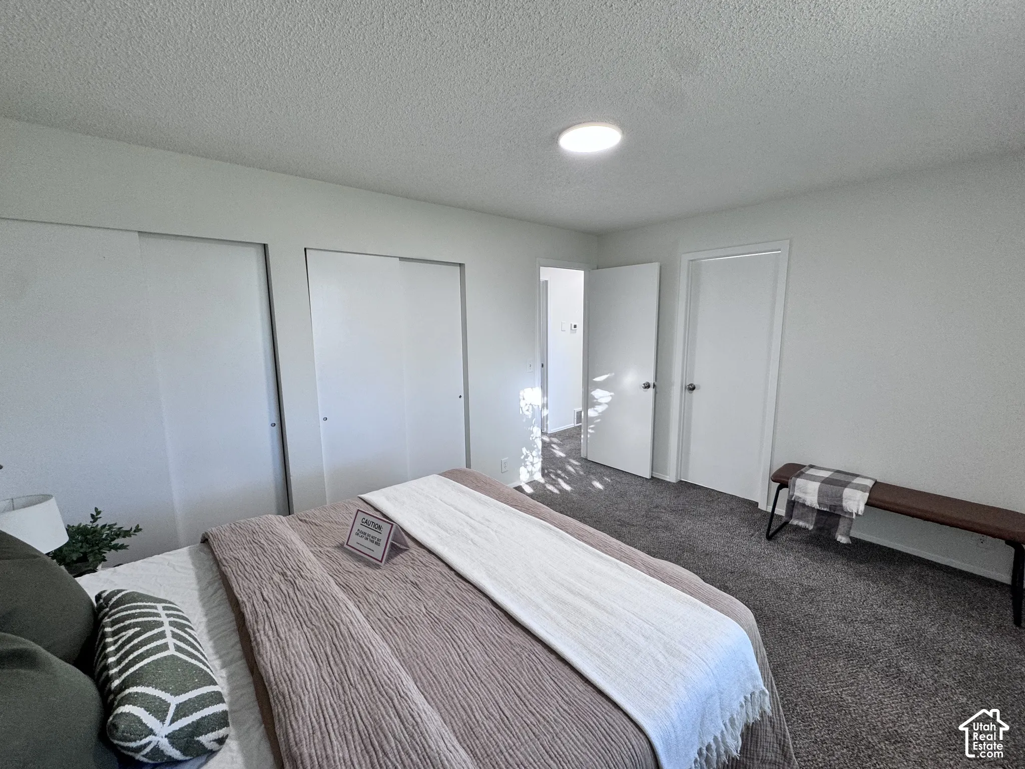Wall-to-wall carpeting with light-toned walls, recessed ceiling lighting, and sliding closet doors