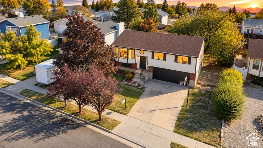 Two-story residence with a two-car garage, concrete driveway, and mature landscaping