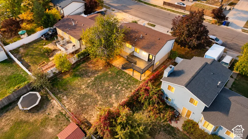 Expansive property featuring a two-story residence with a multi-level deck, a detached shed, and a large, fenced yard with mature trees