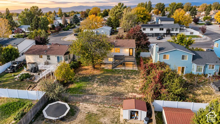 Property featuring a spacious backyard, elevated deck, and a shed