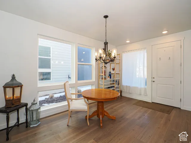 Wood-finish flooring, recessed lighting, and a modern chandelier