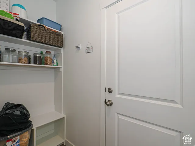 White paneled door with bronze hardware, built-in shelving, and a storage bench