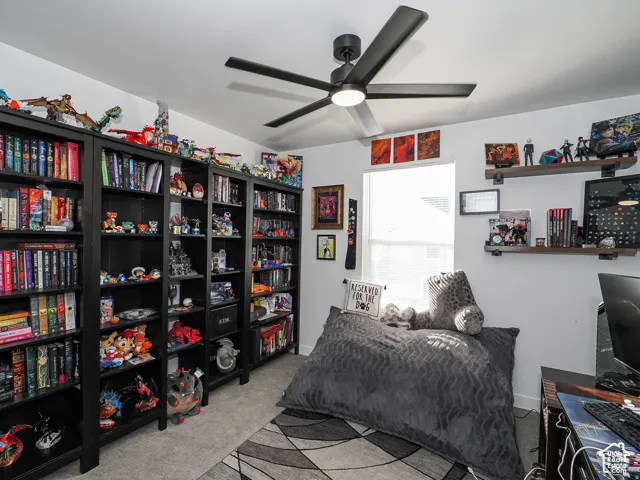 Recessed lighting, ceiling fan with integrated light, multiple built-in shelving units, wall-mounted display shelves, and a window with blinds