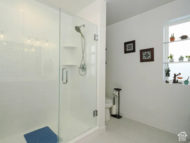 Enclosed shower with glass paneling, white subway tile surround, and a chrome shower fixture