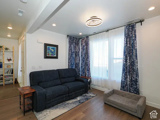 Recessed lighting, wood-finish flooring, white walls, and a modern ceiling light fixture