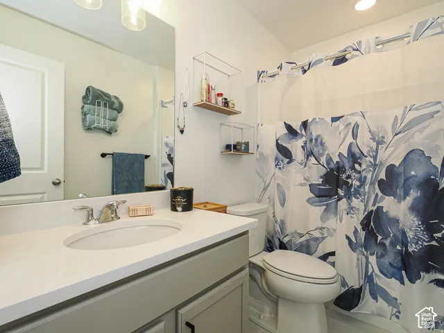 Bathroom featuring a vanity with a white countertop, undermount sink, and chrome faucet