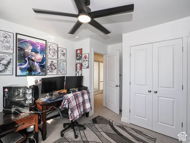 White walls with crown molding, ceiling fan with integrated lighting, two-panel interior doors, and carpet flooring
