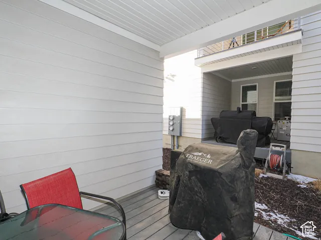 Covered patio with a slatted composite deck and light-colored siding