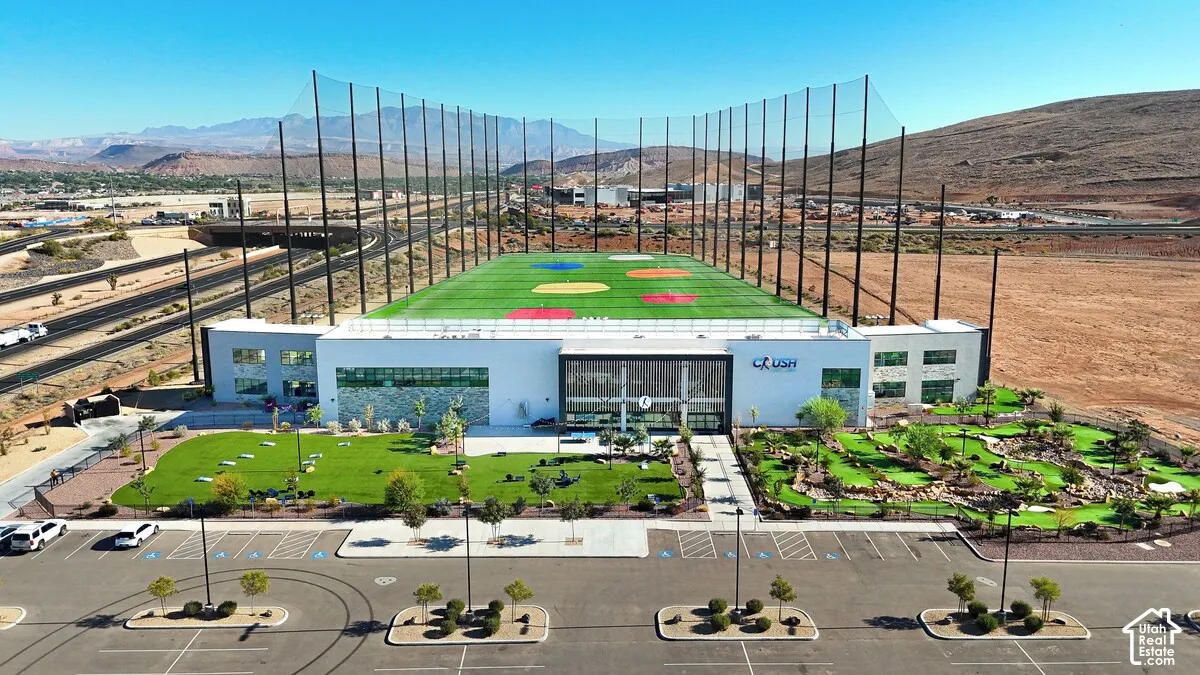 Modern commercial building featuring an expansive driving range, a miniature golf course, and a landscaped green space