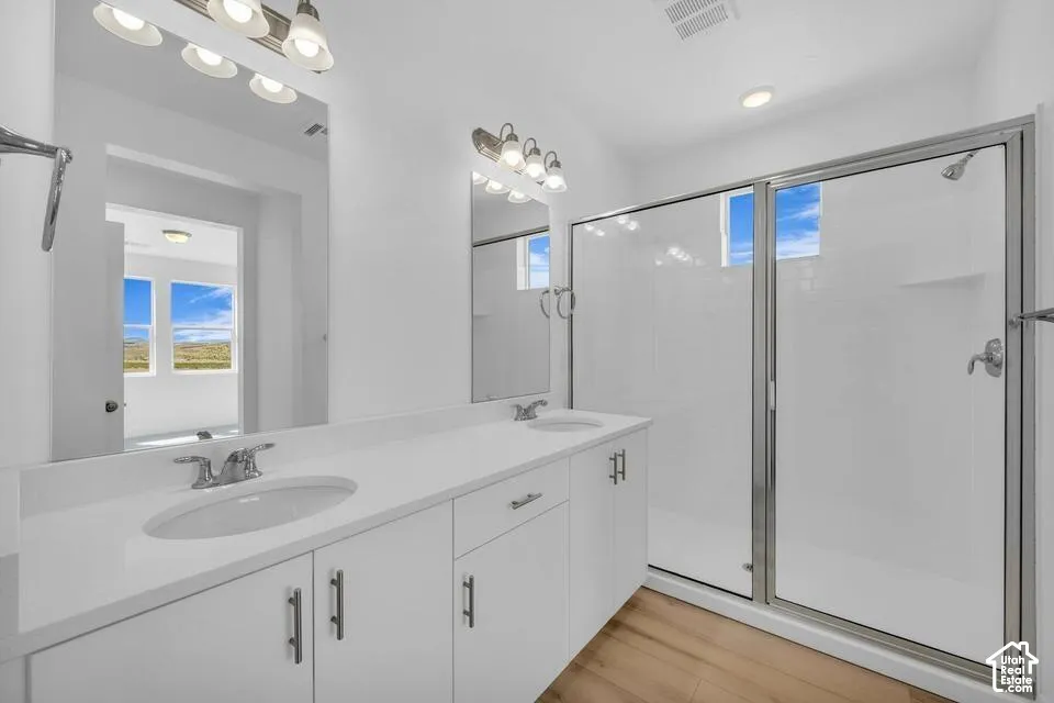 Dual vanity with integrated sinks, white cabinetry, and brushed nickel hardware