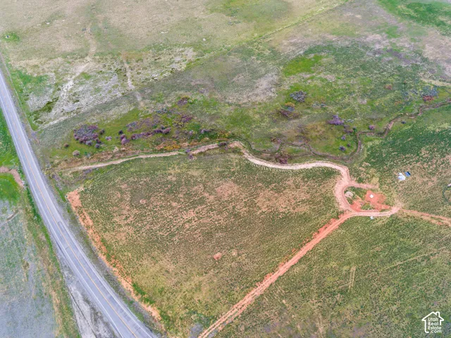 Expansive undeveloped land featuring a paved road, natural waterways, and varied terrain