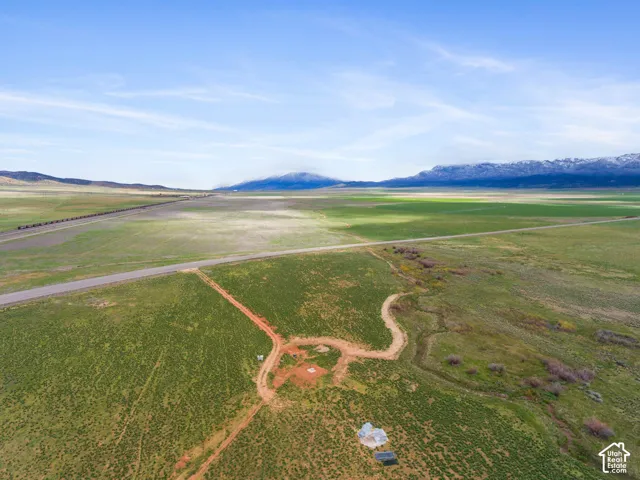 Expansive green landscape with a paved road and natural terrain