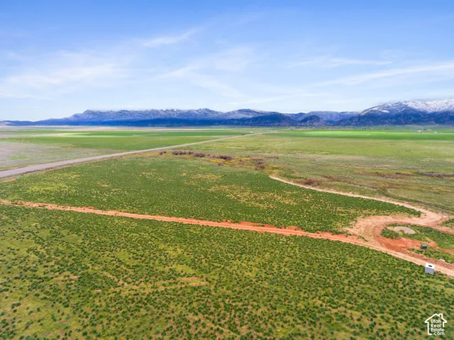 Expansive land parcel with surrounding natural terrain and a distant mountain range